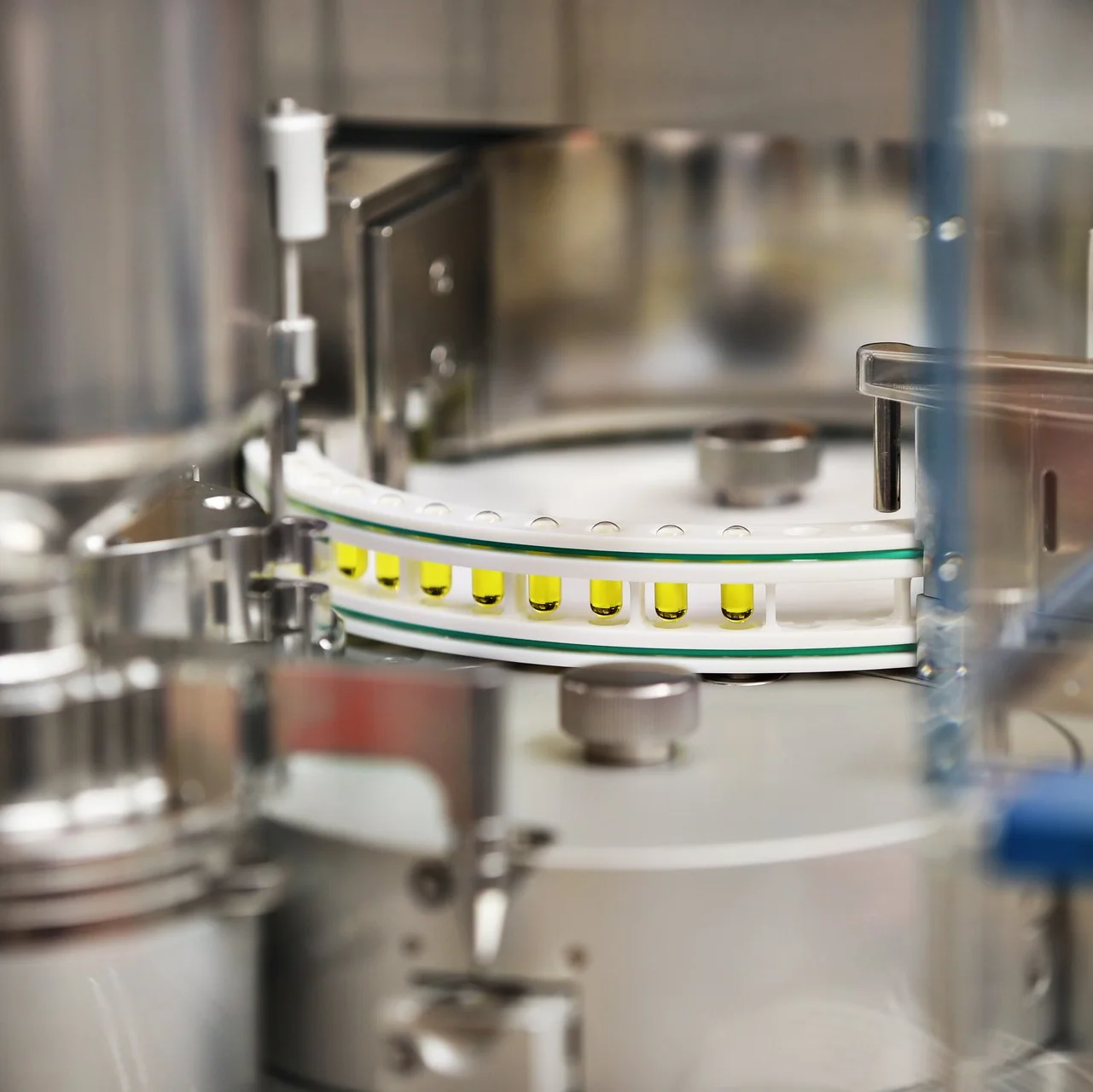 Automatisierte Verblisterungsanlage in der Apotheke, die Medikamente in Becher/Blister portioniert und über ein Förderband weiterleitet.